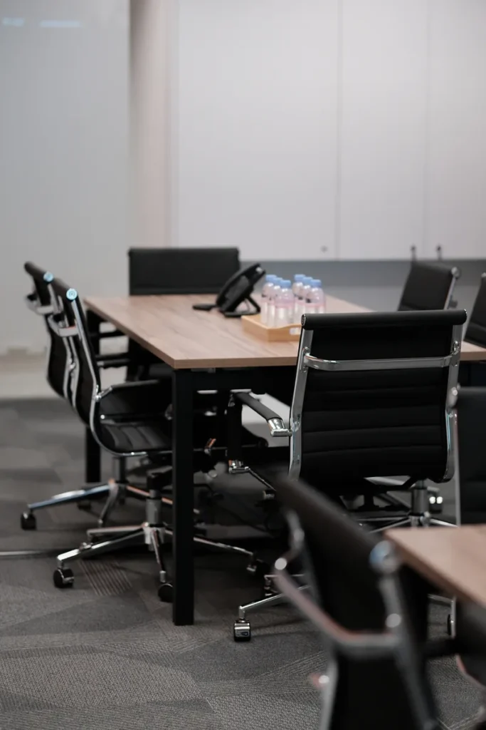 Modern meeting room in C-Work Singapore with conference table, chairs, and AV equipment in a serviced office setting